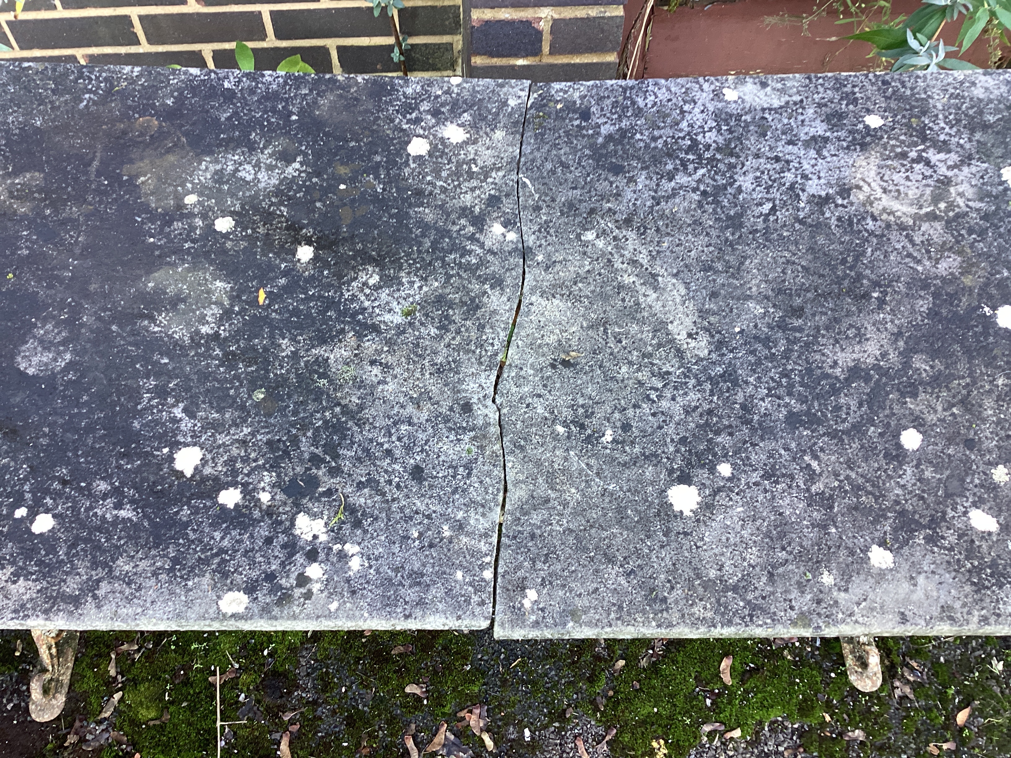 A Victorian painted cast iron garden table with weathered marble top, together with a similar table with damaged marble top, larger width 153cm, height 70cm.
